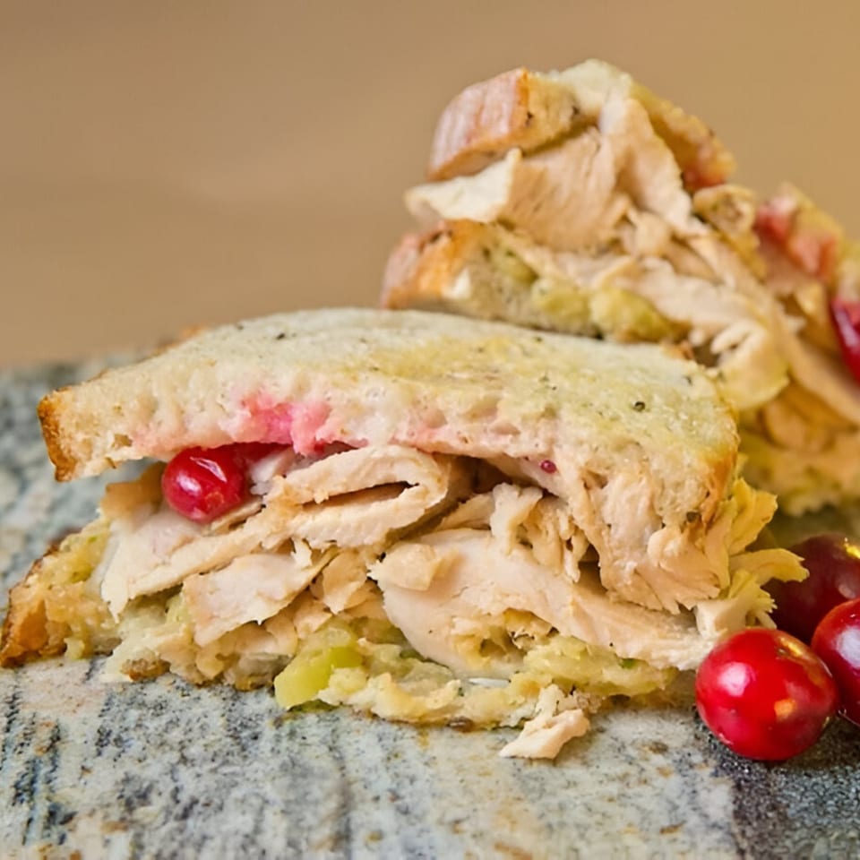 A Beantown Pastrami deli sandwich with turkey, stuffing, and cranberries on toasted bread.